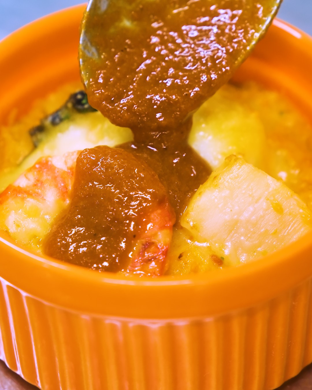 グラタンにソースをかけるシーン